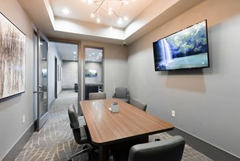a conference room with a large screen tv on the wall